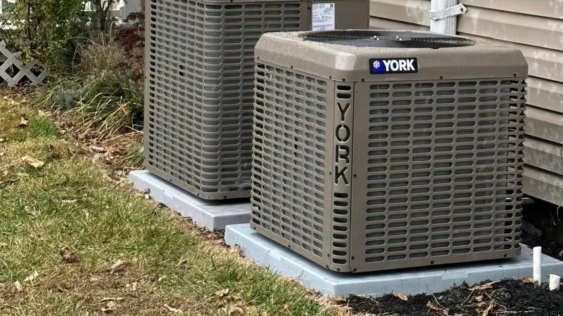 Two new YORK condensers set on fresh pads beside a Cape May County home