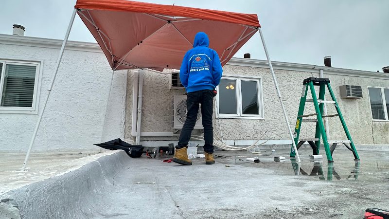 Comfort Pro technician working on a rooftop air conditioning unit under a work canopy