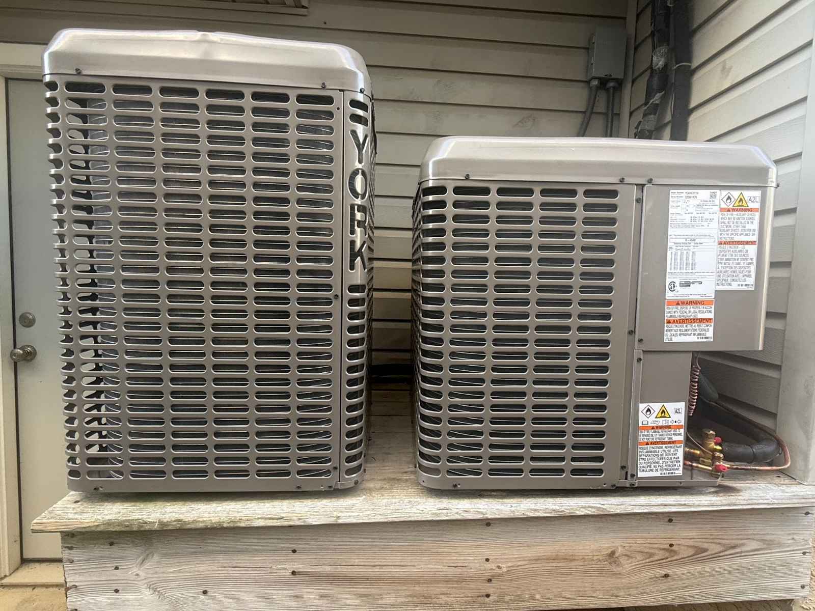 Two YORK condensers installed on a raised platform beside a home in Rio Grande NJ